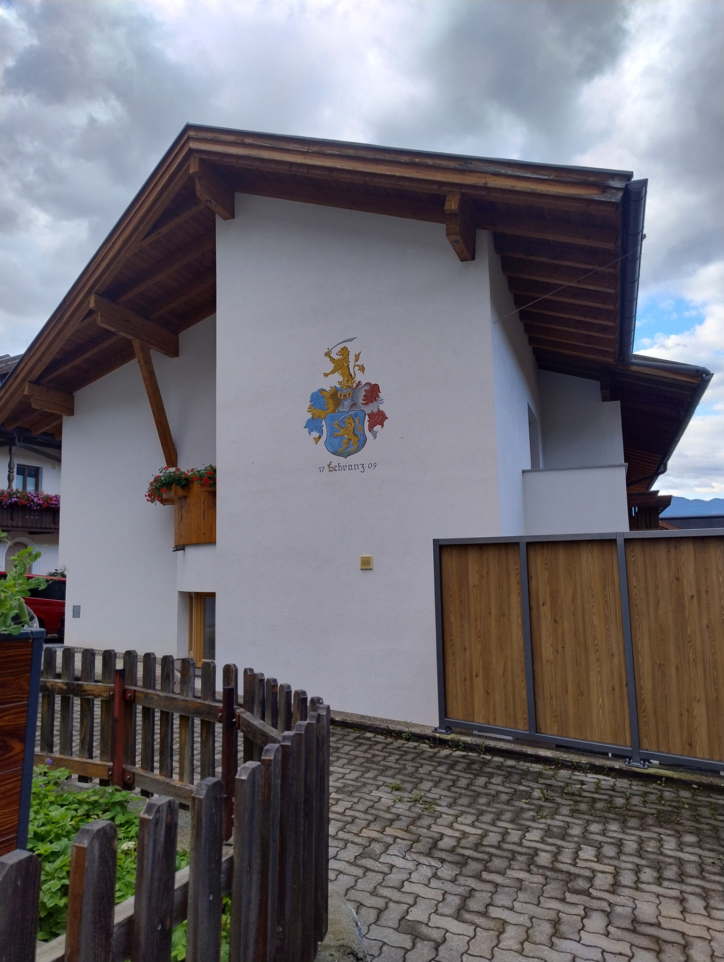 Familievåbenskjold malet på facaden af et moderne alpehus i Fiss, Tyrol, Østrig, hvor heraldik stadig er en levende familietradition.