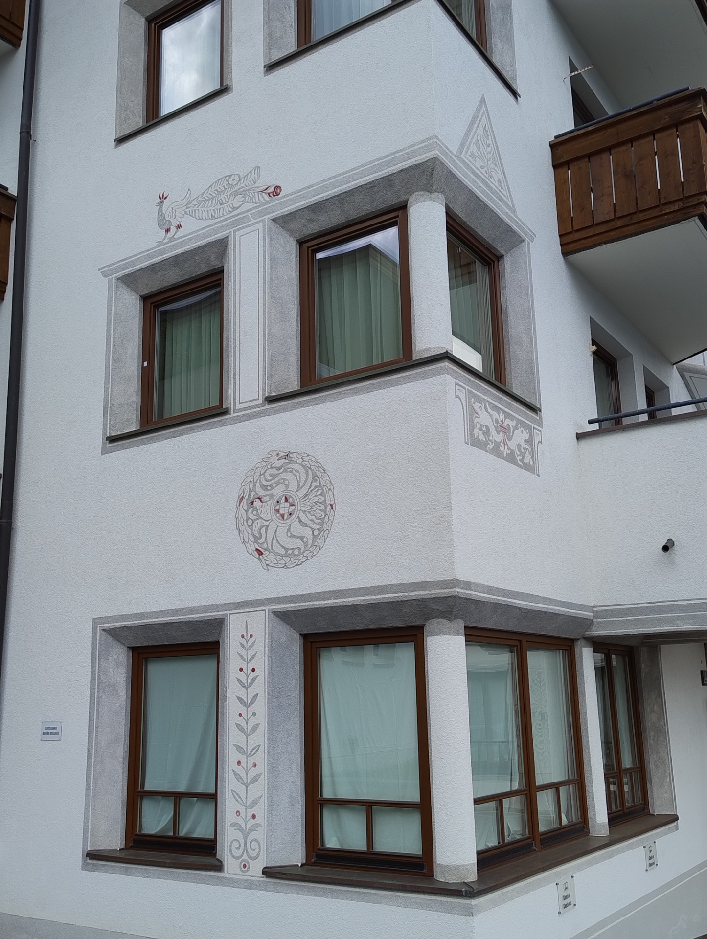 Moderne facadeudsmykning med dekorative heraldiske motiver på hus i Fiss, Tyrol.